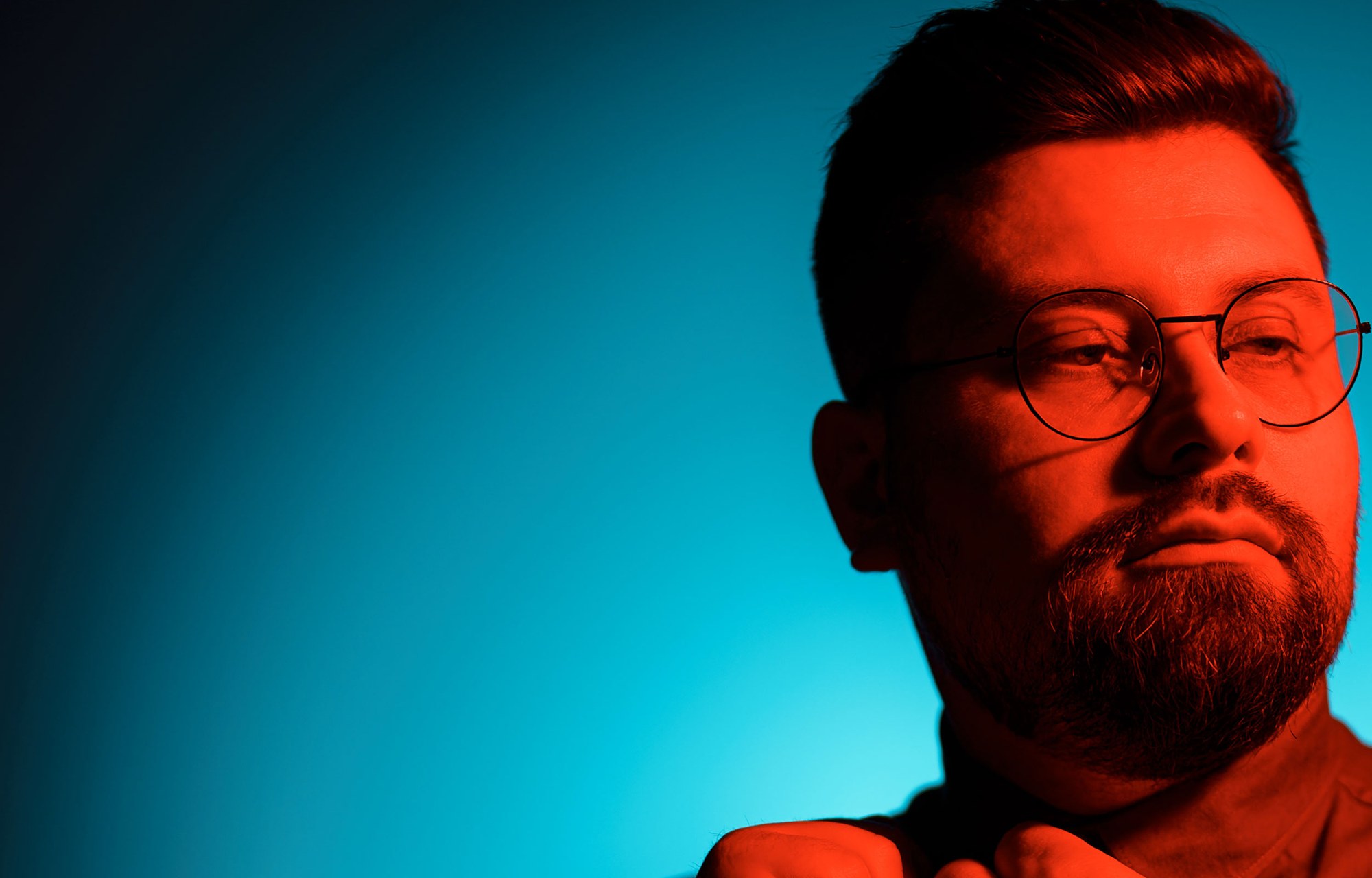 Portrait in bright orange and cyan light