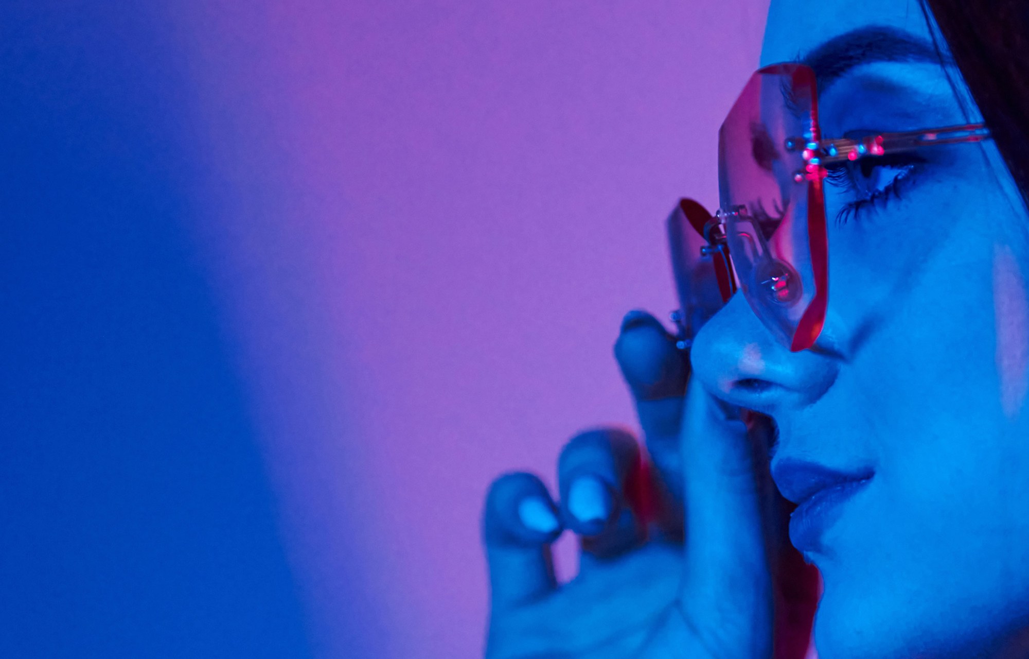 Close portrait with pink glasses in blue light